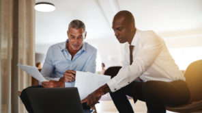 Two men looking pointing at a laptop