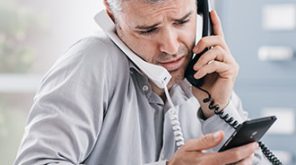 Man on two phone calls with a phone in his hand