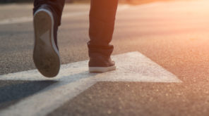 Female walking in blue Sneakers with an Arrow on the floor