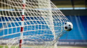 Football hitting the back of a football net